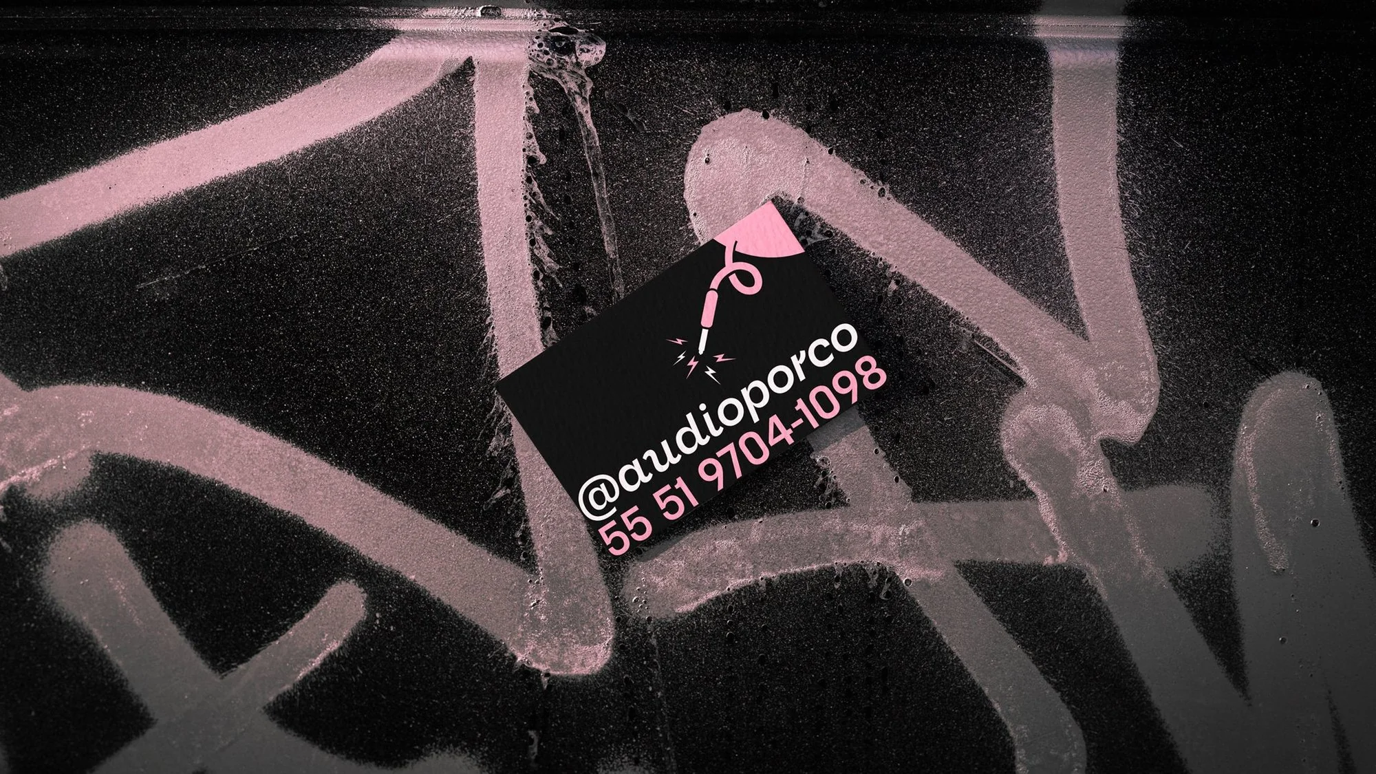 Black Áudio Porco tag with the studio handle over pink graffiti