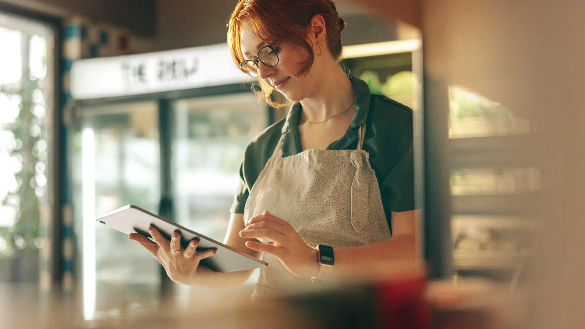 Shop owner checking stock on a tablet