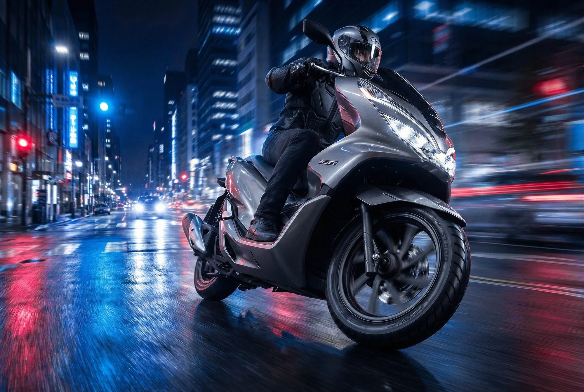 Honda PCX riding through a neon city at night