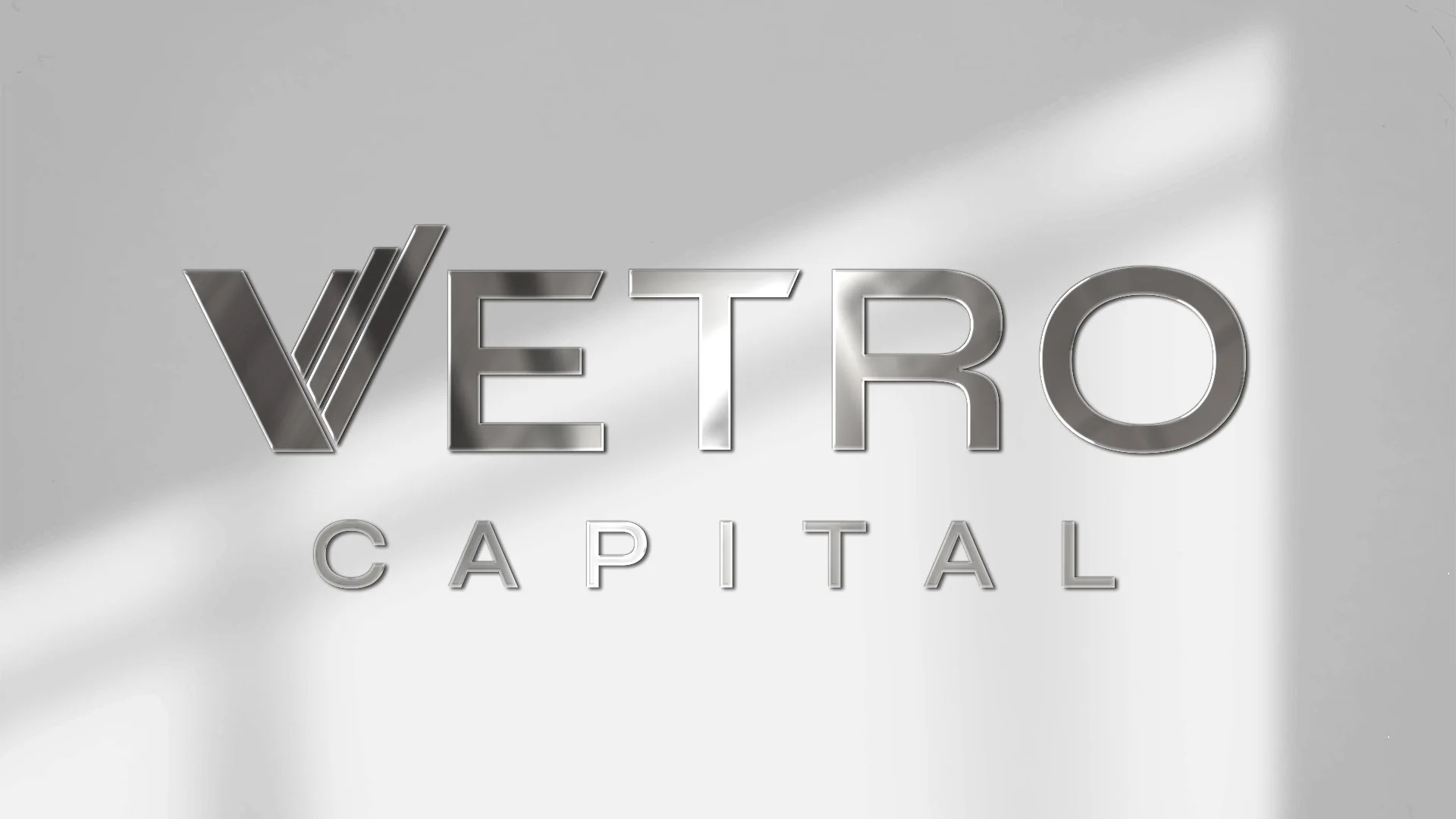 Vetro Capital logo in brushed metal on a white wall